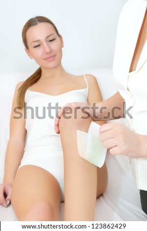 Young women waxing legs