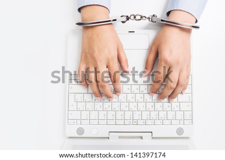Female hands in handcuffs with laptop