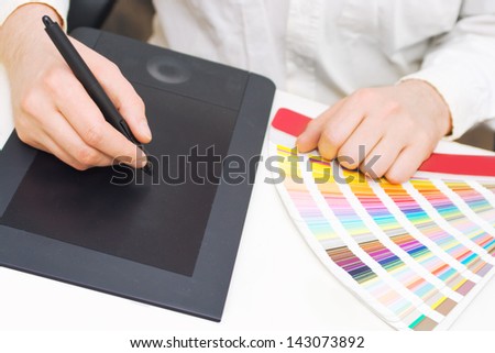 Graphic design, printing, advertising Graphic designer working with digitizer and pantone palette