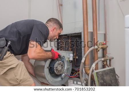 Hvac repair technician removing a blower motor from air handler
