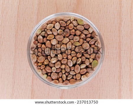 hemp seeds in a bowl on a wooden plate