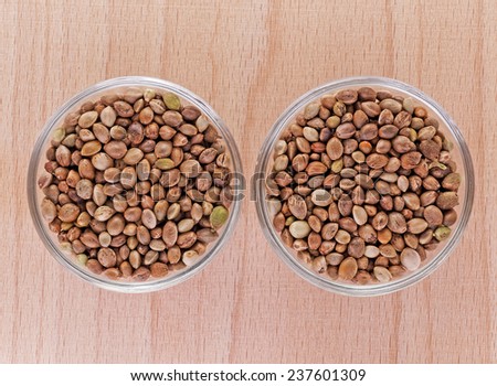 hemp seeds in small bowls on a wooden plate