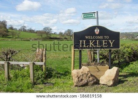 Ilkley town sign in uk with footpath sign and Yorkshire view
