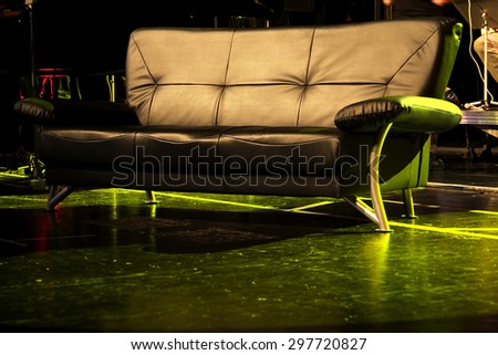 A skin couch on a rock concert, green spot light,