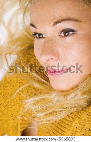 Beautiful young woman wearing yellow sweater. Blonde. Long hair.