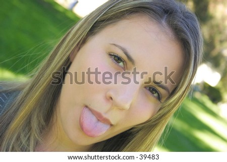 A beautiful young woman sticking out her tongue.
