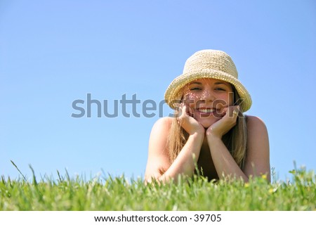 A beautiful young woman relaxing in the grass.