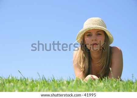 A beautiful young woman laying in the grass.