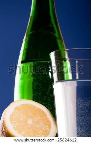 green bottle with lemon and glass