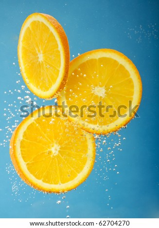 Fresh orange dropped into water