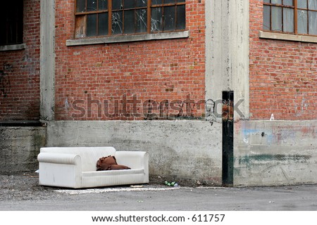 homeless living room in the city, a couch in an old industrial alley