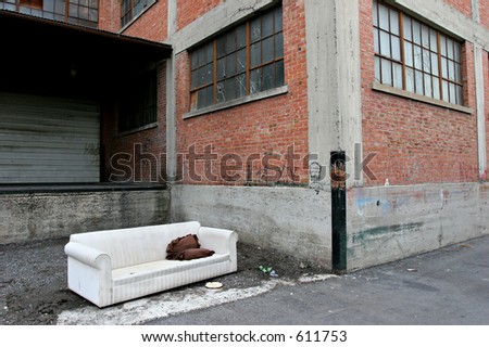 homeless living room - couch out in an old industrial alley