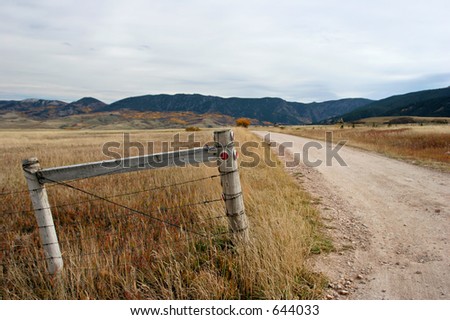 fence by a road leading into the mountains, focus on post