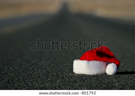 end of christmas holidays - a lost or abandoned santa hat lies on the highway. shallow dof with focus on hat.