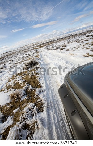 road less traveled - suv exploring a remote road in wyoming covered with snow and frost