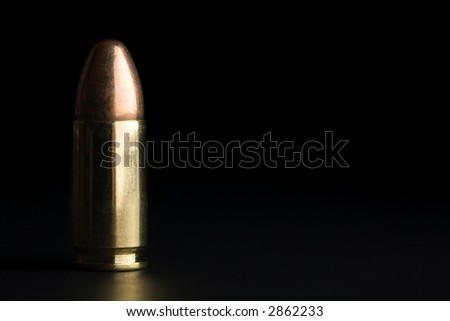 bullet macro with limited dof on a black background, 9mm full metal jacket