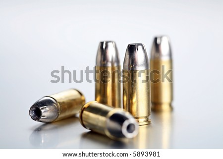 bullets 9mm - closeup of 9mm silvertipped rounds on a cold brushed metal background