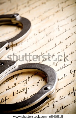 handcuffs closeup on United States Constitution with focus on Liberty