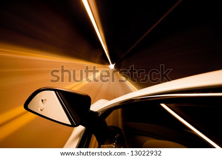 car driving through tunnel with motion blur, focus on mirror