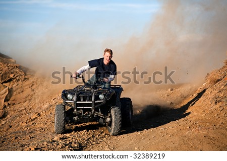teenager male riding a quad / four wheeler in rural Wyoming