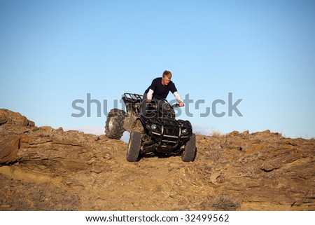 teen on ATV quad - four wheeler going down sandstone hills