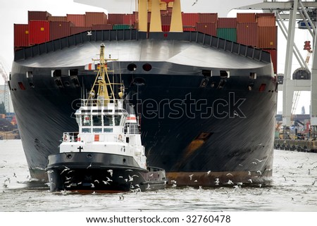 tugboat towing container ship freighter in harbor