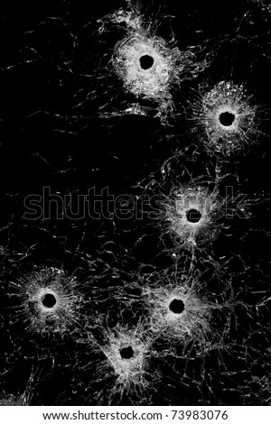 bullet holes in glass - authentic bullet holes from handgun - background or design element isolated on black