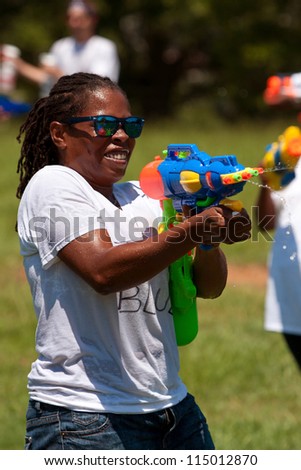 ATLANTA, GA - JULY 28:  An unidentified woman takes part in a water gun battle called the Fight4Atlanta, a squirt gun fight between dozens of locals at Freedom Park on July 28, 2012 in Atlanta.