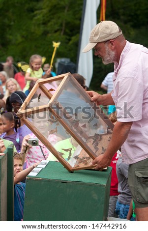 ROSWELL, GA - JULY 13:  An unidentified man releases butterflies from a box, as the crowd looks on at the Chattahoochee Nature Center\'s Butterfly Festival on July 13, 2013 in Roswell, GA.