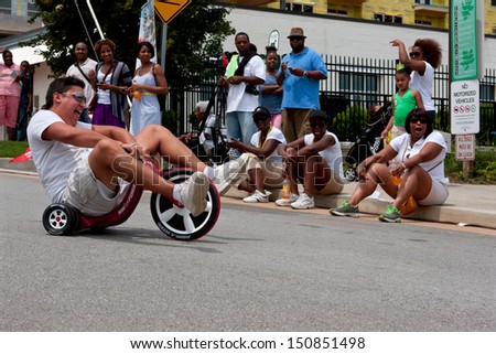 ATLANTA, GA - AUGUST 3:  An unidentified man rides downhill on a Big Wheel at the Cool Dads Rock Soap Box Derby, at the Old 4th Ward Park on August 3, 2013 in Atlanta.
