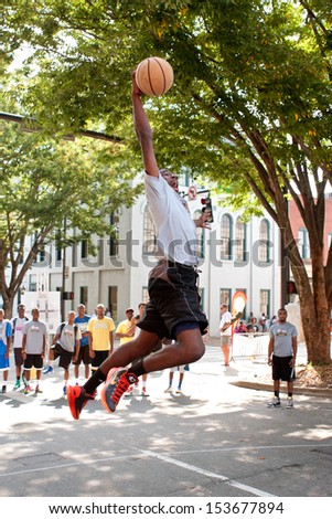 ATHENS, GA - AUGUST 24:  A young man leaps to slam dunk the basketball in an impromptu dunk competition, in between games at a 3-on-3 basketball tournament on August 24, 2013, in Athens, GA.