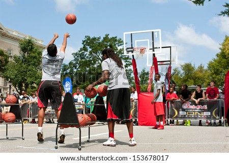 ATHENS, GA - AUGUST 24:  A young man takes part in the three-point shot contest, which was part of a 3-on-3 basketball tournament held on the streets of Athens, on August 24, 2013 in Athens, GA.