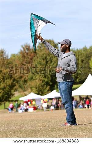 ATLANTA, GA - OCTOBER 26:  A man holds a kite high to get it airborne, at the World Kite Festival in Piedmont Park on October 26, 2013 in Atlanta, GA.  The event was free and open to the public.