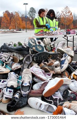 Lawrenceville, Ga - November 23: Two Teen Volunteers Sort Tennis Shoes Then Toss Them Into A Pile, At Gwinnett County\'S America Recycles Day Event On November 23, 2013 In Lawrenceville, Ga.