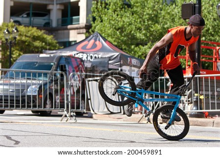 ATHENS, GA - APRIL 26:  A young man practices his flatland tricks before the start of the BMX Trans Jam competition on the streets of downtown Athens, on April 26, 2014 in Athens, GA.