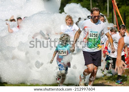LAWRENCEVILLE, GA - MAY 31:  A father and son run through a huge cloud of bubbles and foam at Bubble Palooza, on May 31, 2014 in Lawrenceville, GA.
