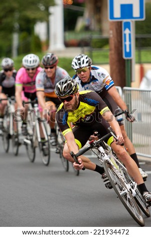 DULUTH, GA - AUGUST 2:  A group of cyclists race into a turn on a downtown Duluth street as they compete in the Georgia Cup Criterium event on August 2, 2014 in Duluth, GA.