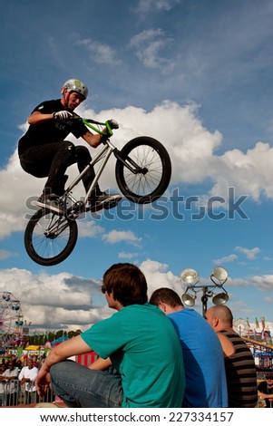 HAMPTON, GA - SEPTEMBER 27:  A young man with the High Roller BMX club performs a stunt jumping over three teens sitting on the ramp, at the Georgia State Fair on September 27, 2014 in Hampton, GA.