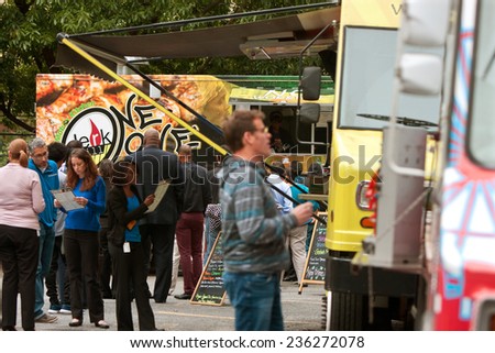 ATLANTA, GA - OCTOBER 16:  Customers stand in line to order meals from popular food trucks during their lunch hour, at \