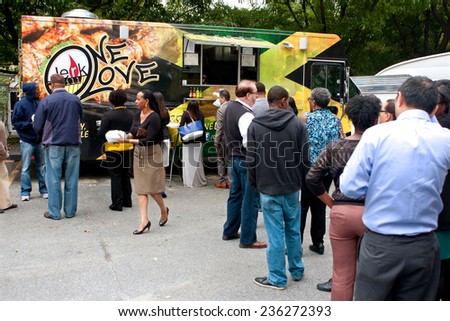 ATLANTA, GA - OCTOBER 16: Customers stand in long line to order meals from food trucks during their lunch hour, at \