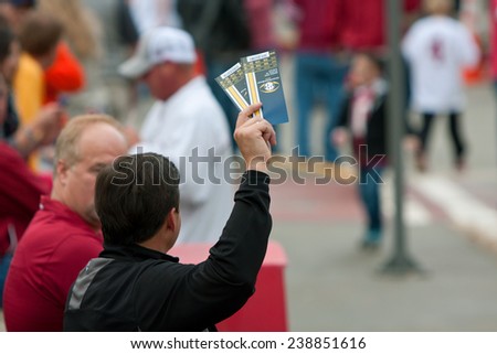 ATLANTA, GA - DECEMBER 6:  An unidentified man tries to sell two tickets to the SEC Championship game, outside the Georgia Dome on December 6, 2014 in Atlanta, GA.