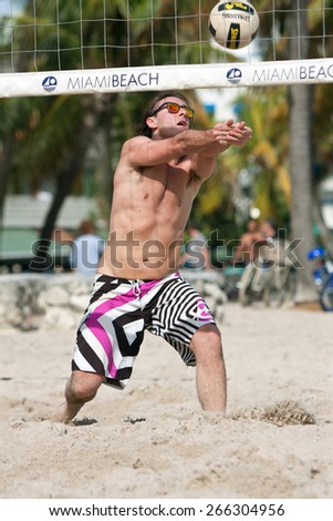 MIAMI, FL - DECEMBER 27:  A man uses his extended arms to pass the ball in a recreational pickup game of beach volleyball on a public beach off Ocean Drive, on December 27, 2014 in Miami, FL.