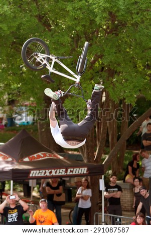 ATHENS, GA - APRIL 25:  Young BMX pro flips upside down performing trick in the pro BMX competition at the annual Athens Twilight Criterium, on April 25, 2015 in Athens, GA.