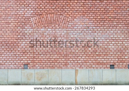 Brick wall with obsolete door bricked up on a stone foundation
