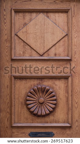 Close up of old wooden door decorated with diamond and flower carved in wood