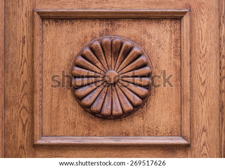 Close up of old wooden door decorated with flower carved in wood