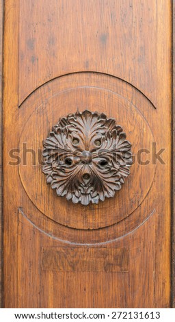Close up of old wooden door decorated with flower carved in wood