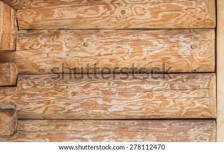 Traditional highland cottage wall made of debarked spruce trunks