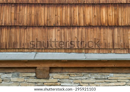 Old larch wood shingle wall with stone foundation