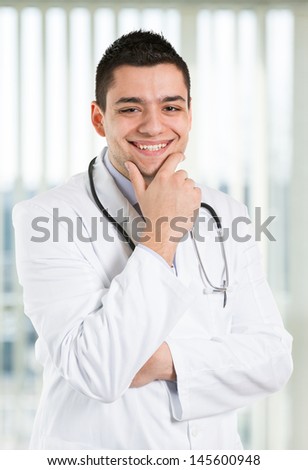 Handsome doctor smiling and looking at you.